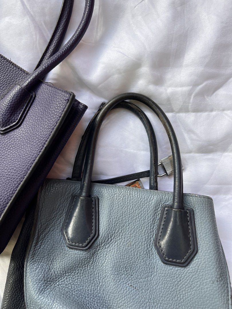 Michael Kors Handbag Lot Two Totes (Category: Tote Bags) located in Manila. Submitted by mightylion-ce6ea7 (Listing ID 1470032028, Image 3). Description: - Authentic Michael Kors Tote Bag Bundle (Set of 2) - Bag 1: Purple textured leather with metal eyelet grommets, diamond patterns, and hanging padlock charm - Bag 2: Dual-tone blue and black pebbled leather with silver padlock accent - Storage: Both feature secure zippered middle compartments an