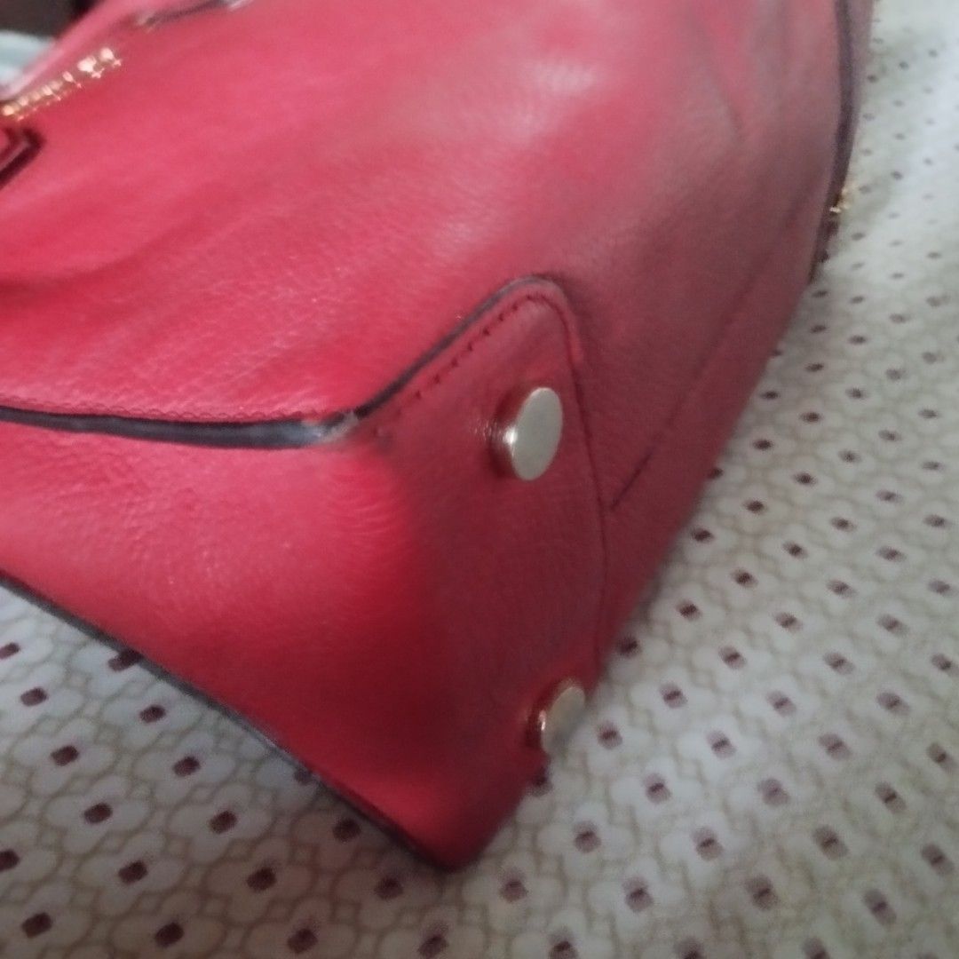 Michael Kors Red Leather Tote Bag (Category: Tote Bags) located in Manila. Submitted by lene48 (Listing ID 1469966390, Image 3). Description: - Brand: Michael Kors - Material: Premium red pebbled leather - Hardware: Elegant gold-tone accents - Storage: Spacious interior with a center zipped compartment and multiple slip pockets - Carry options: Double top handles and an adjustable shoulder strap - Protection: Metal feet on the base - Condition: E