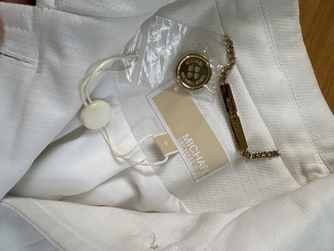 Michael Kors Trench Coat (Category: Coats, Jackets and Outerwear) located in Muntinlupa City. Submitted by jane226ph (Listing ID 1470089414, Image 2). Description: Original Michael Kors New, never worn, kept in prolonged storage. Size US 6 Color White Gold metallic buttons hardware Button down front with multiple flap pockets Tags attached Purchased in the USA Sold as-is.