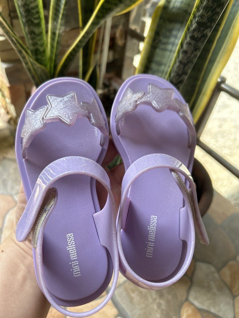 Mini Melissa Purple Star Sandals Size 13 US (Category: Babies & Kids Fashion) located in Gapan. Submitted by mysticrabbit-3195 (Listing ID 1469968666, Image 1). Description: - Brand: Mini Melissa - Color: Purple with glittery star straps - Closure: Easy hook-and-loop ankle strap - Material: Vegan, made in Brazil - Size: USA 13, EUR 31, BRA 29, JPN 19 - Condition: Clean footbeds with visible branding.