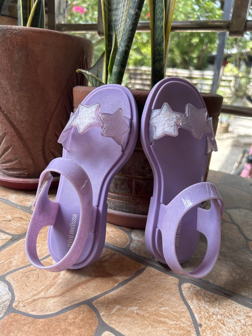 Mini Melissa Purple Star Sandals Size 13 US (Category: Babies & Kids Fashion) located in Gapan. Submitted by mysticrabbit-3195 (Listing ID 1469968666, Image 2). Description: - Brand: Mini Melissa - Color: Purple with glittery star straps - Closure: Easy hook-and-loop ankle strap - Material: Vegan, made in Brazil - Size: USA 13, EUR 31, BRA 29, JPN 19 - Condition: Clean footbeds with visible branding.
