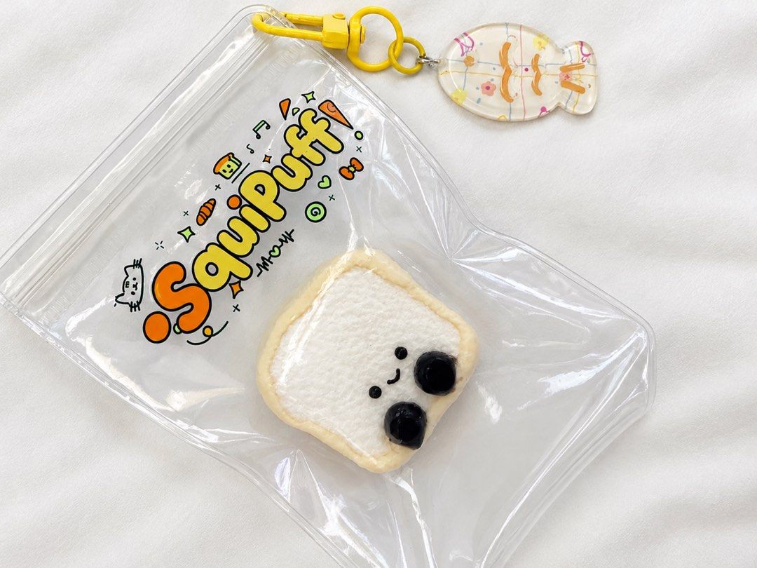 Mini taba squishy Toast Bread Squishy with Bag and Fish Charm (Category: Designer & Blind Box Toys) located in Manila. Submitted by nagets1001 (Listing ID 1470052862, Image 1). Description: - Adorable SquipPuff toast squishy featuring a happy face and bubble tea pearls - Made from super soft foam for great stress relief and satisfying squishes - Comes in a clear zipper pouch for easy storage and display - Includes a cute yellow clasp and a transp
