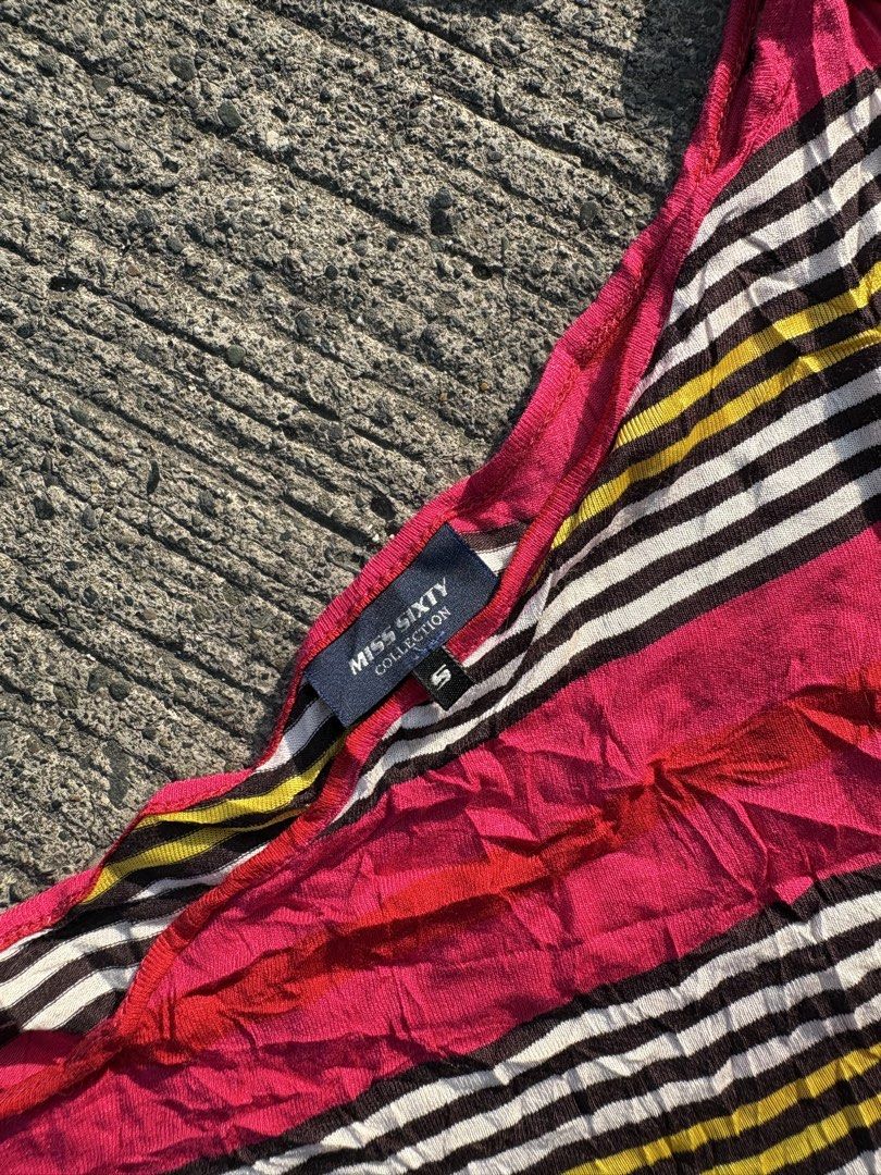 Miss Sixty Multi-color Striped One-shoulder Top (Category: Blouses) located in Iligan City. Submitted by seddicmoti2002 (Listing ID 1470138729, Image 3). Description: - Brand: Miss Sixty - Size: S (fits true to size) - Design: Asymmetric one-shoulder with halter tie strap and draped sleeve - Pattern: Bright pink, yellow, brown, and white stripes - Material: Lightweight knit fabric - Detail: Metal logo tag near the bottom hem - Condition: Great ca
