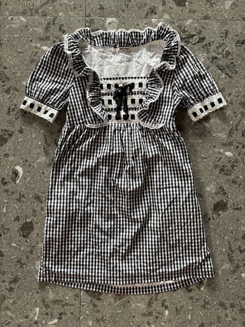 Miu Miu Black White Gingham Pattern Bow Dress (Category: Dresses) located in Cebu City. Submitted by stylingtrends.coll (Listing ID 1470100145, Image 2). Description: - Pattern: Black and white gingham check - Design: Square neckline, white cut-out trim with black front bows, ruffle collar, and short puff sleeves - Silhouette: Empire waistline with a straight mini skirt - Closure: Convenient side zip Size: Small.