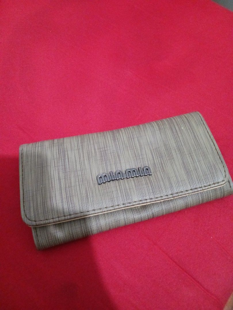 Miu Miu Grey Long Wallet with Patterned Interior (Category: Wallets & Card holders) located in Quezon City. Submitted by rdonelle (Listing ID 1470096320, Image 1). Description: - Colour & Finish: Elegant grey long wallet with a stylish woodgrain texture - Closure: Flap closure with metallic logo plate and secure snap button - Interior Design: Beautiful beige lining with an ornate paisley pattern - Organization: Multiple card slots, clear ID windo