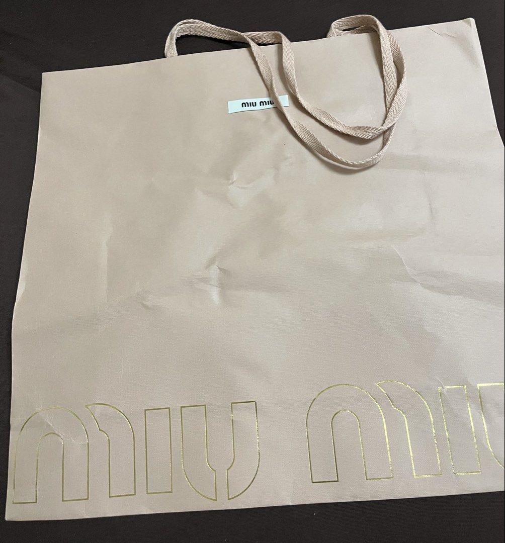 Miu miu paper bag (Category: Wallets & Card holders) located in Bacoor. Submitted by ayit. (Listing ID 1470064360, Image 2). Description: Orig s new personal - Brand: Miu Miu - Item: Shopping paper bag - Color: Neutral beige with gold-toned logo lettering - Handles: Fabric ribbon handles - Features: Includes small Miu Miu brand tag near the top - Condition: Good pre-owned condition - Ideal for: Gifting, collection display, or storage.