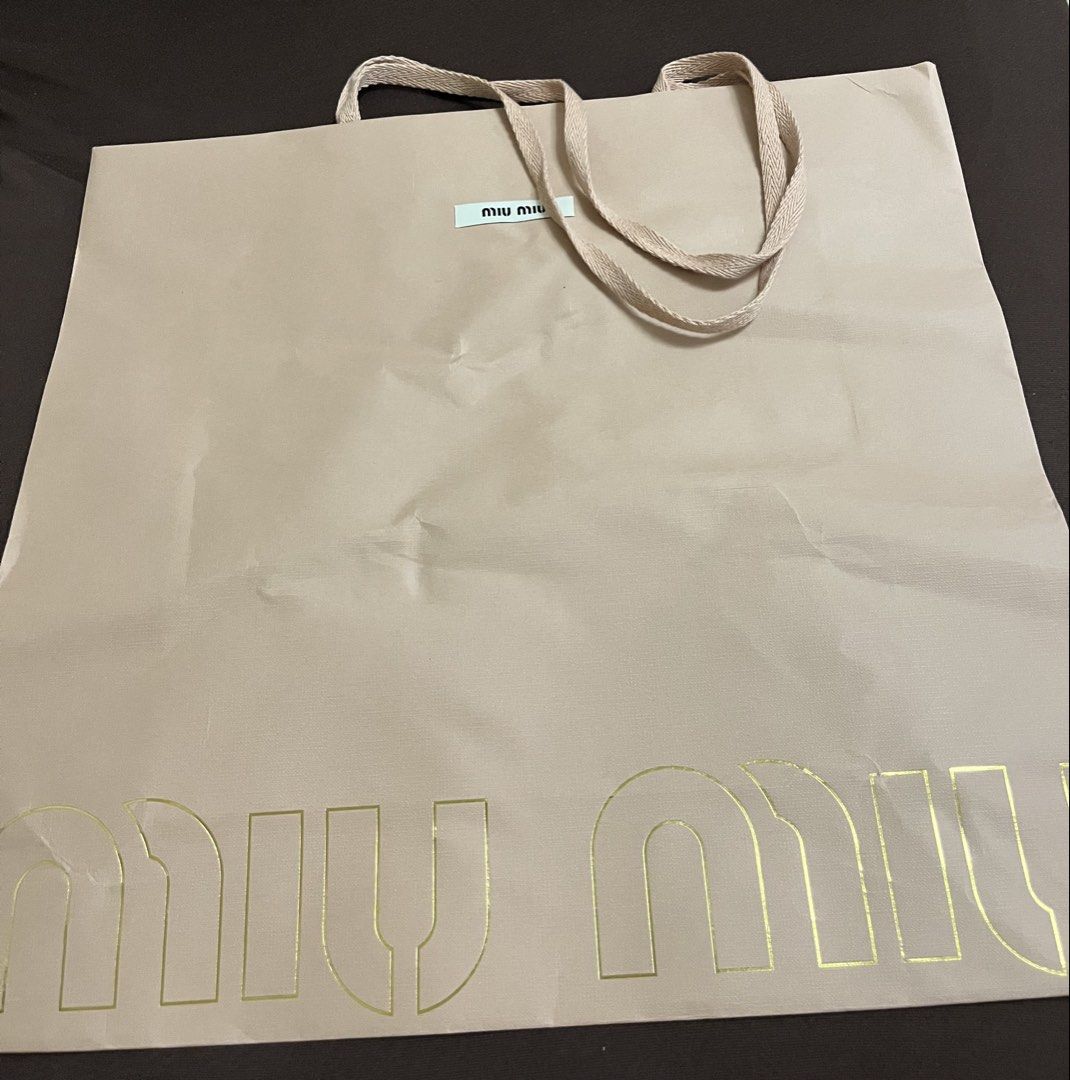 Miu miu paper bag (Category: Wallets & Card holders) located in Bacoor. Submitted by ayit. (Listing ID 1470064360, Image 1). Description: Orig s new personal - Brand: Miu Miu - Item: Shopping paper bag - Color: Neutral beige with gold-toned logo lettering - Handles: Fabric ribbon handles - Features: Includes small Miu Miu brand tag near the top - Condition: Good pre-owned condition - Ideal for: Gifting, collection display, or storage.