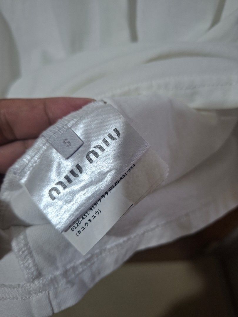 Miu Miu White Polo Shirt (Category: Shirts) located in Quezon City. Submitted by shawnstussy (Listing ID 1470041115, Image 3). Description: - Brand: Miu Miu - Item: White Polo Shirt - Size: S - Material: 100% Cotton - Origin: Made in Italy - Features: Short sleeves, collar neck, front button placket, and Miu Miu chest logo - Care: Gentle hand wash recommended.