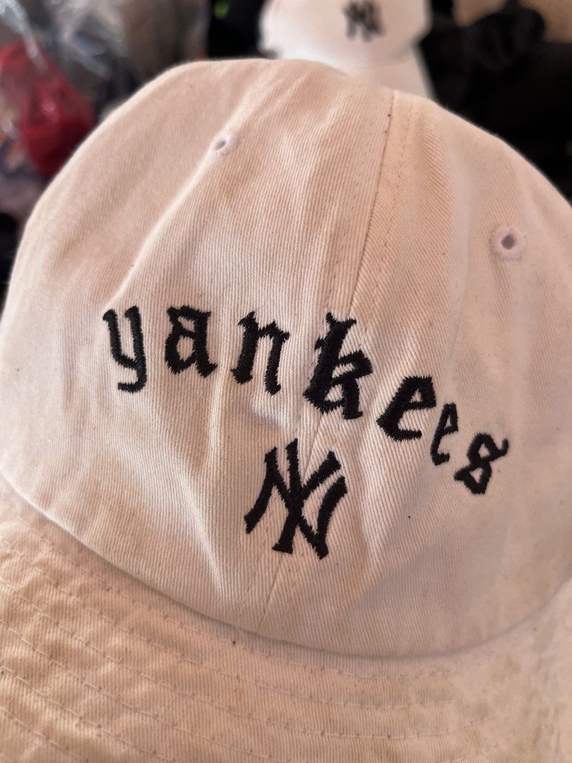 MLB New York Yankees White Bucket Hat (Category: Caps & Hats) located in Pilar. Submitted by fast-flip-ni-miko. (Listing ID 1469989522, Image 2). Description: - Brand: MLB (Major League Baseball) - Team: New York Yankees (front lettering and classic NY logo) - Color: White - Size: Head girth 57 (50W) - Condition: Pre-loved with noticeable yellowing and discoloration on the brim and crown - Details: Interior branding tags intact, great casual stre