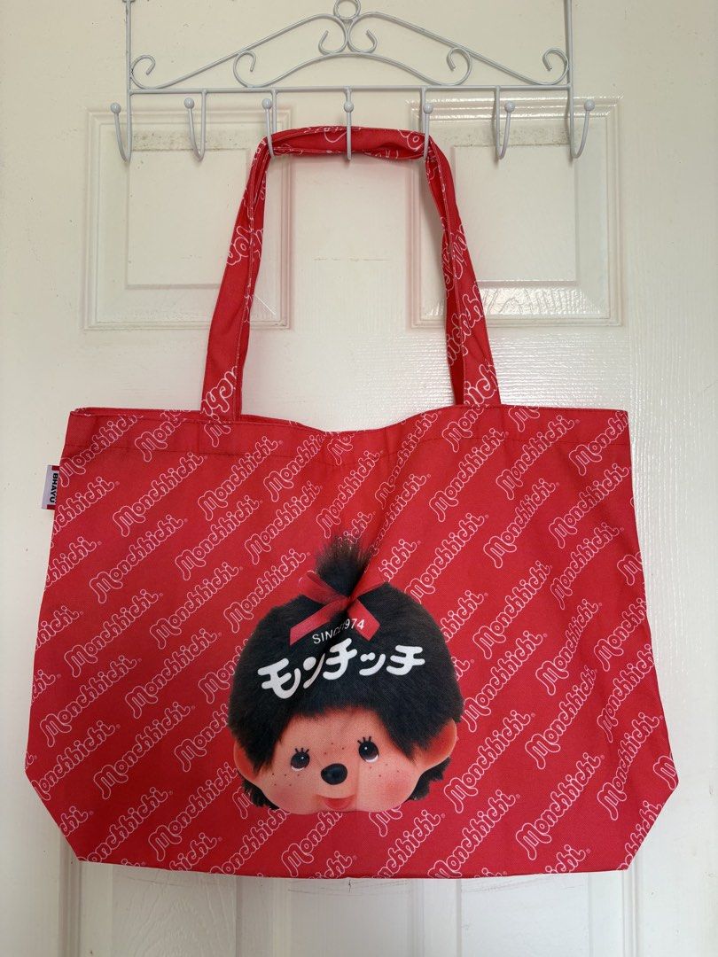 Monchhichi Red Tote Bag With Character Face (Category: Tote Bags) located in Manila. Submitted by konmaribychi (Listing ID 1469971987, Image 1). Description: - Color: Bright red with all-over white brand lettering - Design: Large Monchhichi character face graphic with Japanese text on the front - Straps: Two comfortable top shoulder straps - Material: Lightweight fabric construction.
