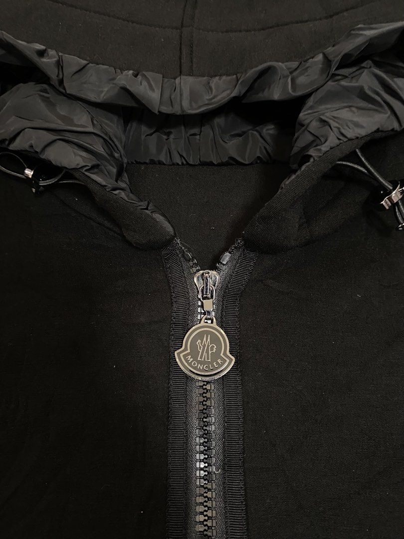Moncler Black Zip Hoodie with Ruffled Hem (Category: Coats, Jackets and Outerwear) located in Manila. Submitted by refit_thrifts_ (Listing ID 1469985992, Image 3). Description: - Brand: Moncler - Color: Classic Black - Style: Hooded zip jacket with chic ruffle trim along the hood and bottom hem - Hardware: Branded metal zipper pull - Pockets: Two secure zipped lower pockets - Details: Adjustable hood drawstrings and comfortable ribbed cuffs - Fla
