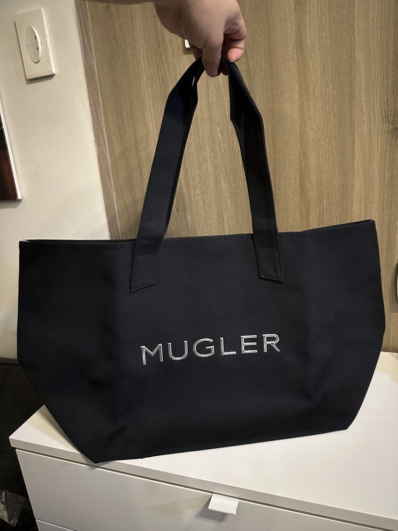 Mugler Parfums Black Canvas Tote Bag (Category: Tote Bags) located in Manila. Submitted by kevintotin49861 (Listing ID 1470088879, Image 1). Description: - Authentic Mugler Parfums black canvas tote bag - Features silver embroidered MUGLER lettering on front and small star logo on back - Light grey interior lining with open pocket and brand tag - Equipped with sturdy shoulder straps for everyday use - Condition: Brand new, never used, clean insid