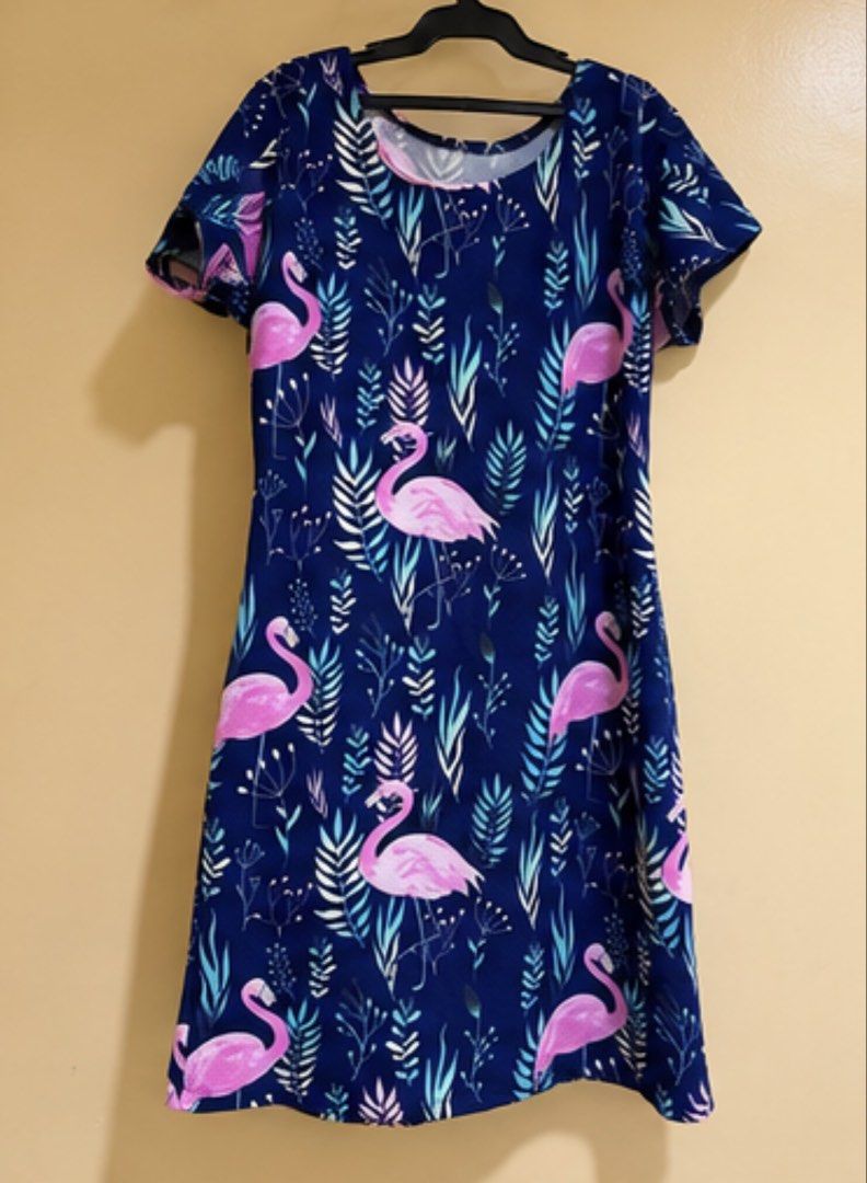 Navy Blue Flamingo Dress (Category: Dresses) located in Manila. Submitted by bunbun_1995 (Listing ID 1469953679, Image 1). Description: - Design: Navy blue with pink flamingos and tropical leaves - Fit: Casual knee-length with a round neckline and short sleeves - Fabric: Smooth, lightweight, and comfortable for warm weather - Condition: Used once only 🫡 📍South Triangle, Quezon City.