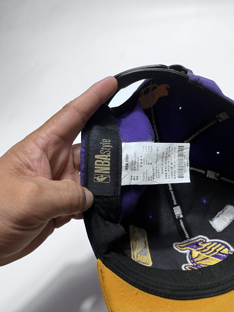NBA Style LA Lakers Snapback Cap Purple Yellow (Category: Caps & Hats) located in Iloilo. Submitted by fromthebins.ilo2 (Listing ID 1470107111, Image 3). Description: - Authentic NBA Style Los Angeles Lakers snapback hat - Vibrant purple crown with a contrasting yellow brim and top button - Premium embroidered Lakers front logo with collectible team patches on the sides and back - Adjustable black plastic snapback closure for a custom fit - Size: