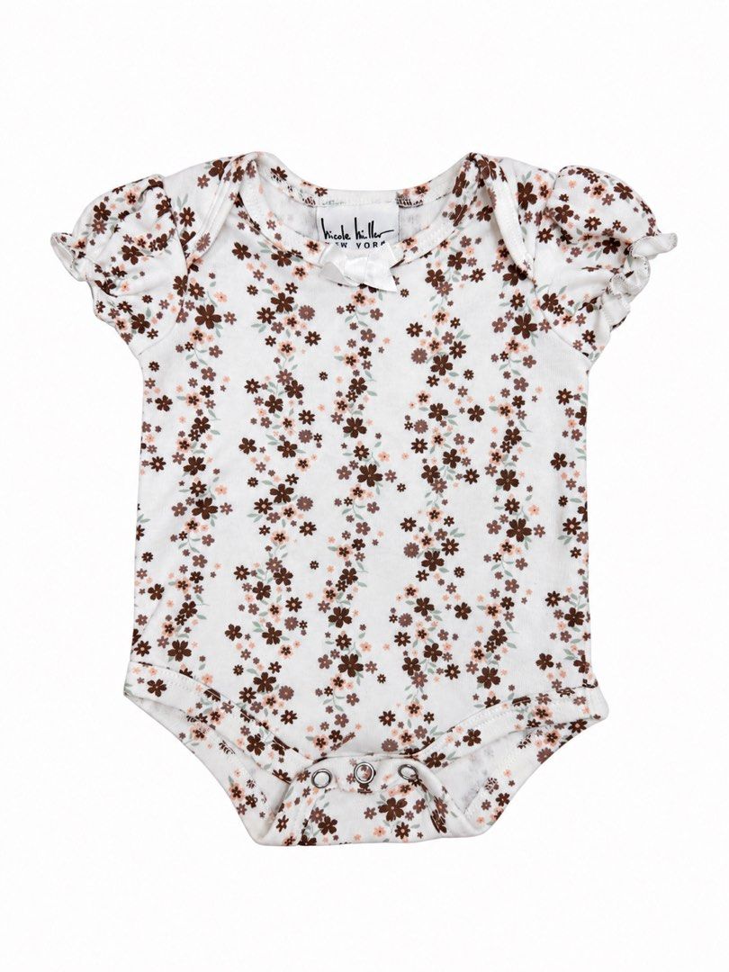 Nicole Miller Onesie (0-3M) (Category: Babies & Kids Fashion) located in Angeles City. Submitted by aeapreloved (Listing ID 1470056794, Image 1). Description: Nicole Miller New York Floral Onesie 🌸 Adorable cream onesie with a dainty brown and pink floral print, cute puff sleeves, and a satin bow detail. • Size: 0–3 months • Short sleeves • Snap-button closure at the bottom .