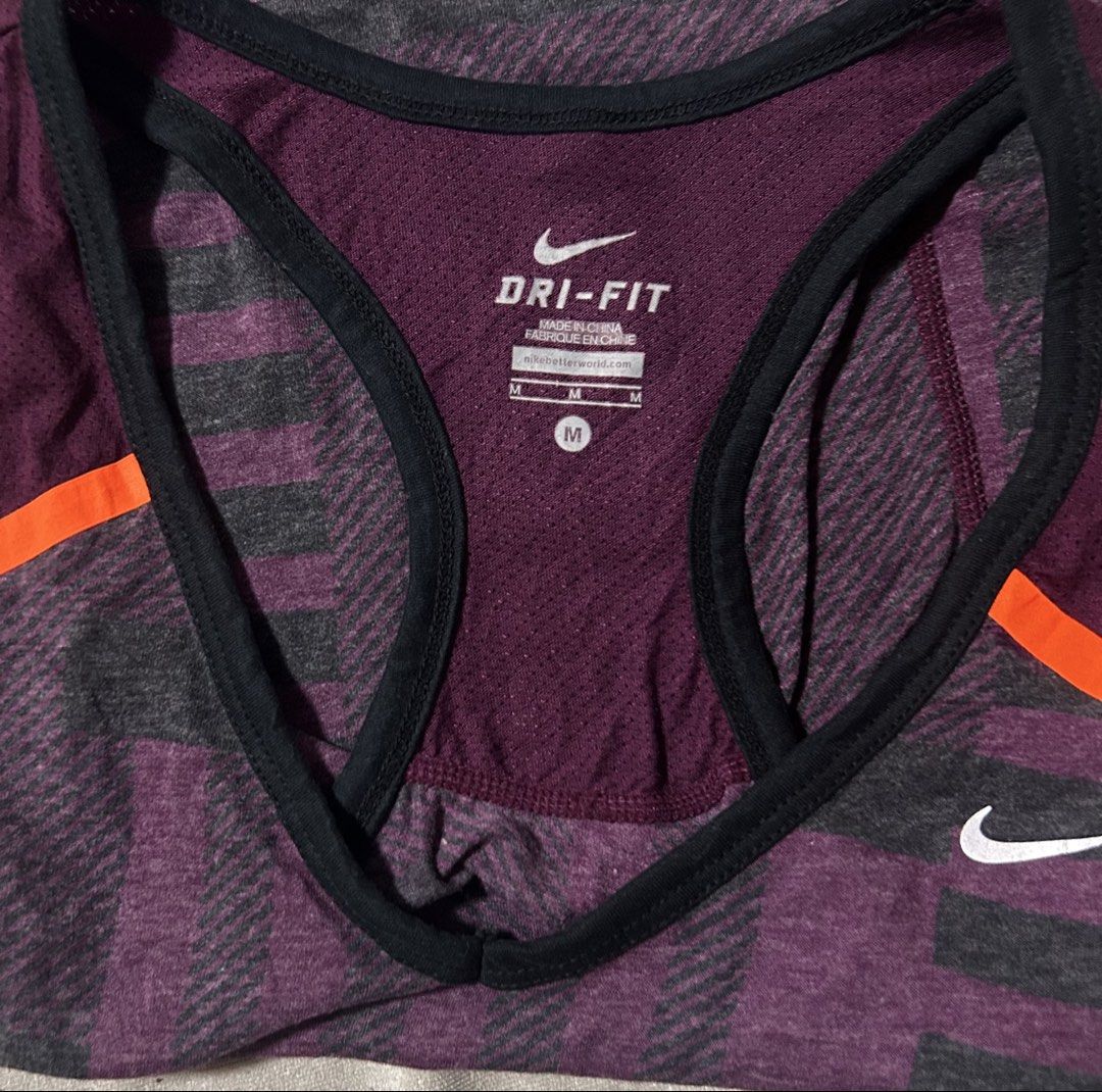 NIKE (Category: Activewear) located in Davao. Submitted by sart0ria85 (Listing ID 1470110307, Image 3). Description: Dri-FIT workout tank top in Purple and dark grey block pattern with orange shoulder accent stripes. Racerback style with back small pocket. 65% ORGANIC COTTON 35% RECYCLED POLYESTER MADE IN CHINA 🇨🇳 MEDIUM. Size 6 EXCELLENT CONDITION (95/100).