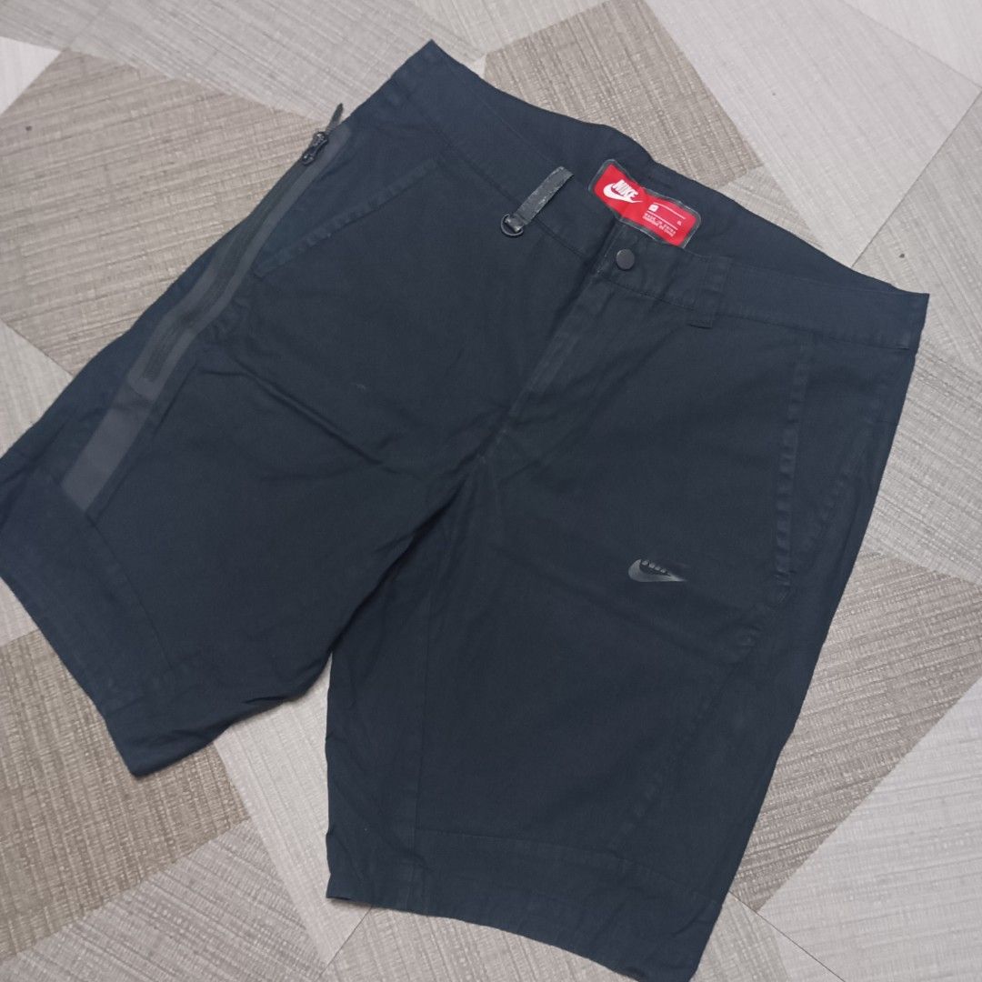 Nike Black Cargo Tech Shorts Size XL (Category: Shorts) located in Manila. Submitted by charleshustla (Listing ID 1470110242, Image 2). Description: - Brand: Nike - Color: Black - Size: XL - Closure: Button closure with belt loops - Pockets: Convenient side zipper utility pocket - Details: Subtle Nike swoosh logo on front left leg and branded red inner waistband tag - Condition: Clean dark wash fabric, perfect for casual wear or training.