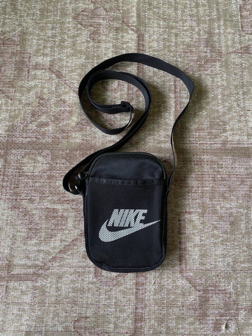 Nike Black Crossbody Bag (Category: Sling Bags) located in Manila. Submitted by diporosmoh43681 (Listing ID 1469976211, Image 1). Description: - Brand: Nike - Color: Classic black with white Nike logo - Material: Durable, high-quality nylon - Closure: Top zipper with black pull cord - Storage: Handy front mesh pocket for easy access - Strap: Fully adjustable for a comfortable fit - Perfect for: Carrying daily essentials like your phone, wallet, a