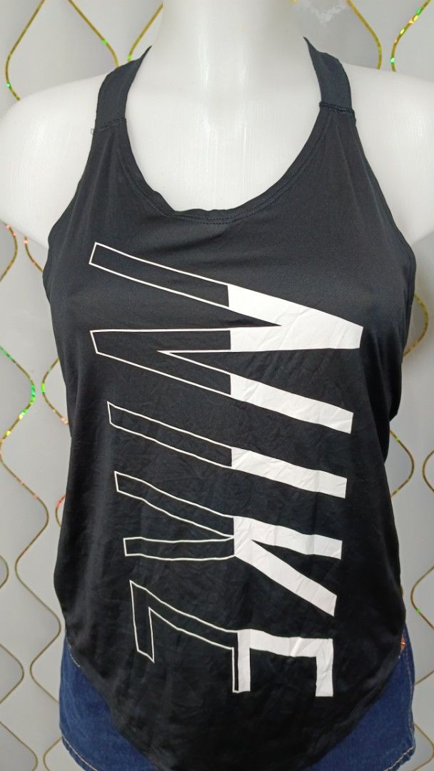 Nike Black Workout Tank Top with Large Vertical Logo (Category: Activewear) located in Manila. Submitted by zariyah.1986 (Listing ID 1469954866, Image 3). Description: - Brand: Nike - Color: Classic black with a bold vertical white logo - Design: Stylish strap detailing on the back featuring the signature 'Just Do It' text - Fit: Racerback cut designed for a full range of motion - Fabric: Lightweight and breathable to keep you cool and dry - Cond