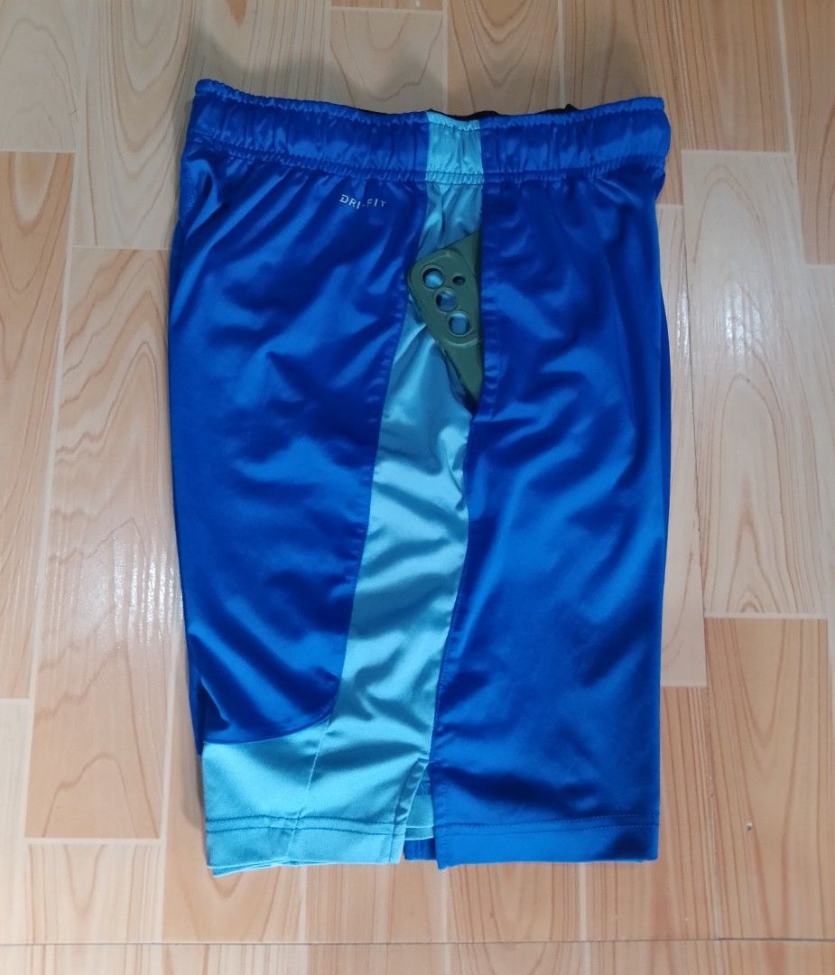 Nike Dri-FIT Blue Athletic Shorts (Category: Shorts) located in San Jose del Monte. Submitted by azetor (Listing ID 1469995269, Image 3). Description: - Brand: Nike - Color: Royal blue and light blue with contrast side panels - Material: Dri-FIT (keeps you dry and comfortable) - Features: Elastic waistband with adjustable black drawstring, and Nike swoosh logo - Ideal for: Running, gym workouts, or casual wear - size medium on tags - Youth size -
