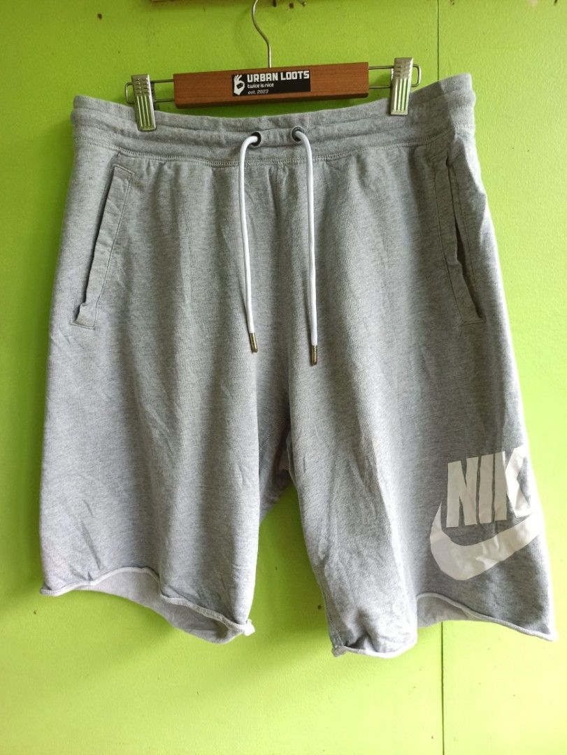 Nike Gray Sweatshorts Size M (Category: Shorts) located in Tagbilaran City. Submitted by delasierra39181 (Listing ID 1470003550, Image 1). Description: - Brand: Nike - Color: Gray - Size: Medium - Material: 100% Cotton (Made in Cambodia) - Design: Large white Nike swoosh graphic on the right leg - Waistband: Elastic with white drawstring cords and metal tips - Pockets: Two side pockets and one back pocket with a small red Nike tag - Hem: Trendy r