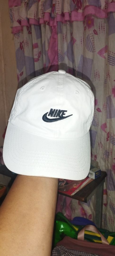 Nike Heritage86 White Cap (Category: Caps & Hats) located in Koronadal. Submitted by jrdar (Listing ID 1470138721, Image 1). Description: - Brand: Nike - Model: Heritage86 Cap - Color: White with dark navy blue embroidered script logo - Design: Classic curved brim with structured front panels and branded interior taping - Closure: Adjustable metal strap for a custom fit - Condition: Brand new / Excellent daily wear staple.