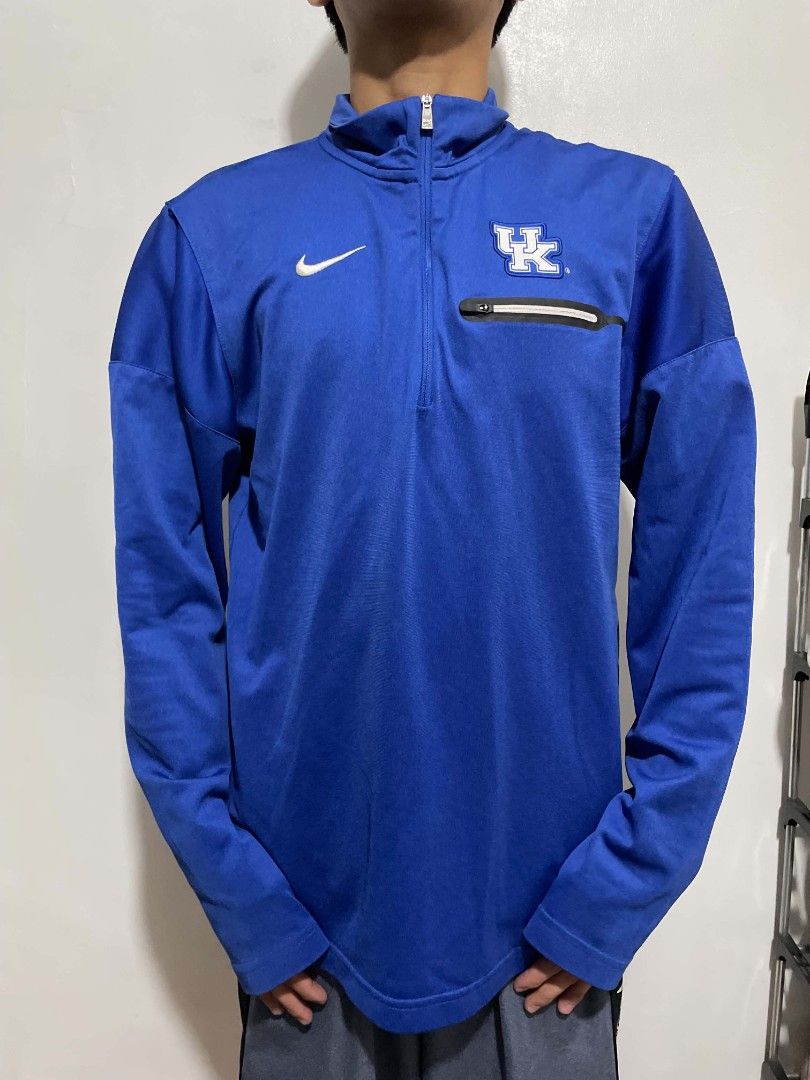 Nike Kentucky Wildcats Dri-FIT 1/4 Zip Pullover Blue (Category: Coats, Jackets and Outerwear) located in Manila. Submitted by mikeee03 (Listing ID 1470050017, Image 1). Description: - Official Nike Kentucky Wildcats quarter-zip pullover in royal blue - Features the iconic UK logo on the left chest and white Nike swoosh on the right - Moisture-wicking Dri-FIT material keeps you cool and dry - Practical zippered chest pocket for small essentials - 