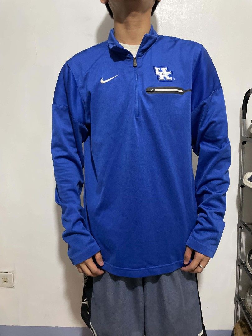 Nike Kentucky Wildcats Dri-FIT 1/4 Zip Pullover Blue (Category: Coats, Jackets and Outerwear) located in Manila. Submitted by mikeee03 (Listing ID 1470050017, Image 2). Description: - Official Nike Kentucky Wildcats quarter-zip pullover in royal blue - Features the iconic UK logo on the left chest and white Nike swoosh on the right - Moisture-wicking Dri-FIT material keeps you cool and dry - Practical zippered chest pocket for small essentials - 