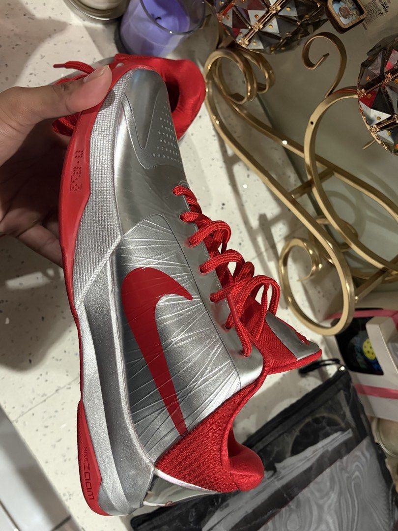 Nike Kobe 5 Protro Caitlin Clark Metallic Silver Red (Category: Sneakers) located in Davao. Submitted by lewgrover (Listing ID 1470019564, Image 3). Description: - Model: Nike Kobe 5 Protro basketball sneakers - Colorway: Metallic silver upper with vibrant red accents and laces - Details: Signature Kobe sheath logo on tongue and red signature on chrome heel counter - Sole: Red rubber outsole with visible carbon fiber shank plate - Condition: Clea