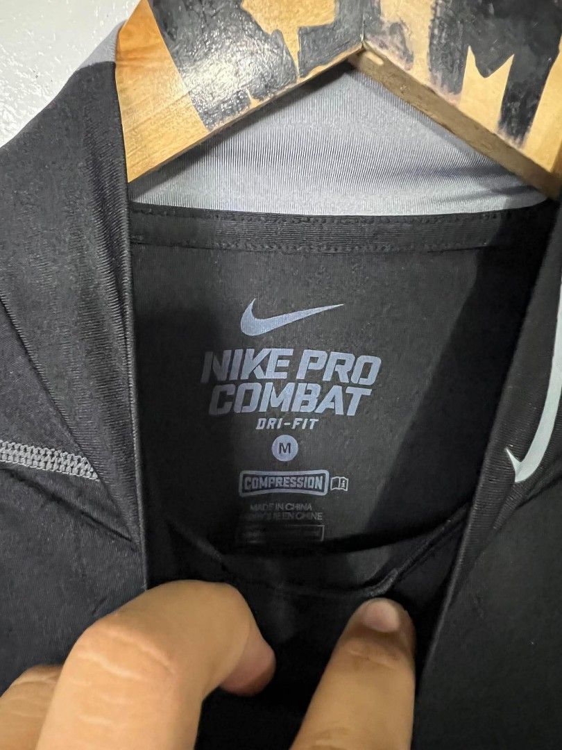 Nike Pro Combat Dri-Fit Compression Shirt Black Medium (Category: Activewear) located in Roxas, Mindoro Oriental. Submitted by oldschool_thriftph (Listing ID 1470108967, Image 3). Description: - Brand/Model: Nike Pro Combat Compression Shirt - Color: Black with grey detailing - Size: Medium - Dimes 15x25 - Style Code: 449833-010 - Material: Dri-FIT fabric for moisture-wicking and dry workouts - Design: Mock neck with branding on collar and lower 