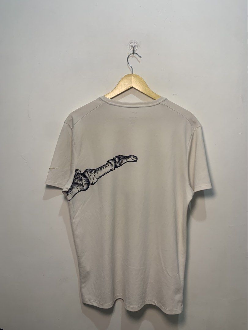 Nike Running Division Bone Graphic T-Shirt (Category: Tshirts & Polo Shirts ) located in Davao. Submitted by legitseller1111 (Listing ID 1470126258, Image 2). Description: - Brand: Nike Running Division - Color: Off-white - Size: Medium on Tag Can fit Up to Large - Material: Dri-FIT, breathable fabric - Design: Vintage-style anatomical foot and bone graphic wrapping front and back, with small swoosh on left sleeve - Condition: Clean, minimalist a