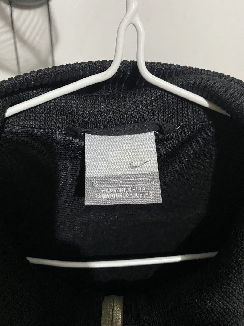 Nike Vintage Black Nylon Track Jacket Size S (Category: Coats, Jackets and Outerwear) located in Angono. Submitted by ronangelo12 (Listing ID 1470111955, Image 2). Description: 00s Nike Y2K Nylon Jacket with Embroidered Swoosh Logo, Black & Gold Size - Small Kindly see last pic for issue Price - 1200 (nego) Loc - Binangonan Rizal / Pasig City MOP - Gcash, Maribank, BOC MOD - Lalamove or meet up.
