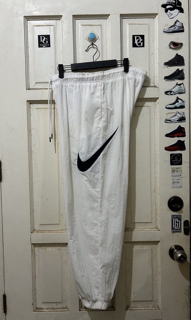 Nike White Track Pants with Big Swoosh (Category: Joggers) located in Pasay City. Submitted by deguzmanjay (Listing ID 1470069951, Image 1). Description: - Authentic white Nike track pants - Large black swoosh logo on the front leg - Elastic waistband with adjustable white drawstrings - Elastic cuffs at the ankles - Lightweight nylon/polyester material - Ideal for casual streetwear and everyday wear.