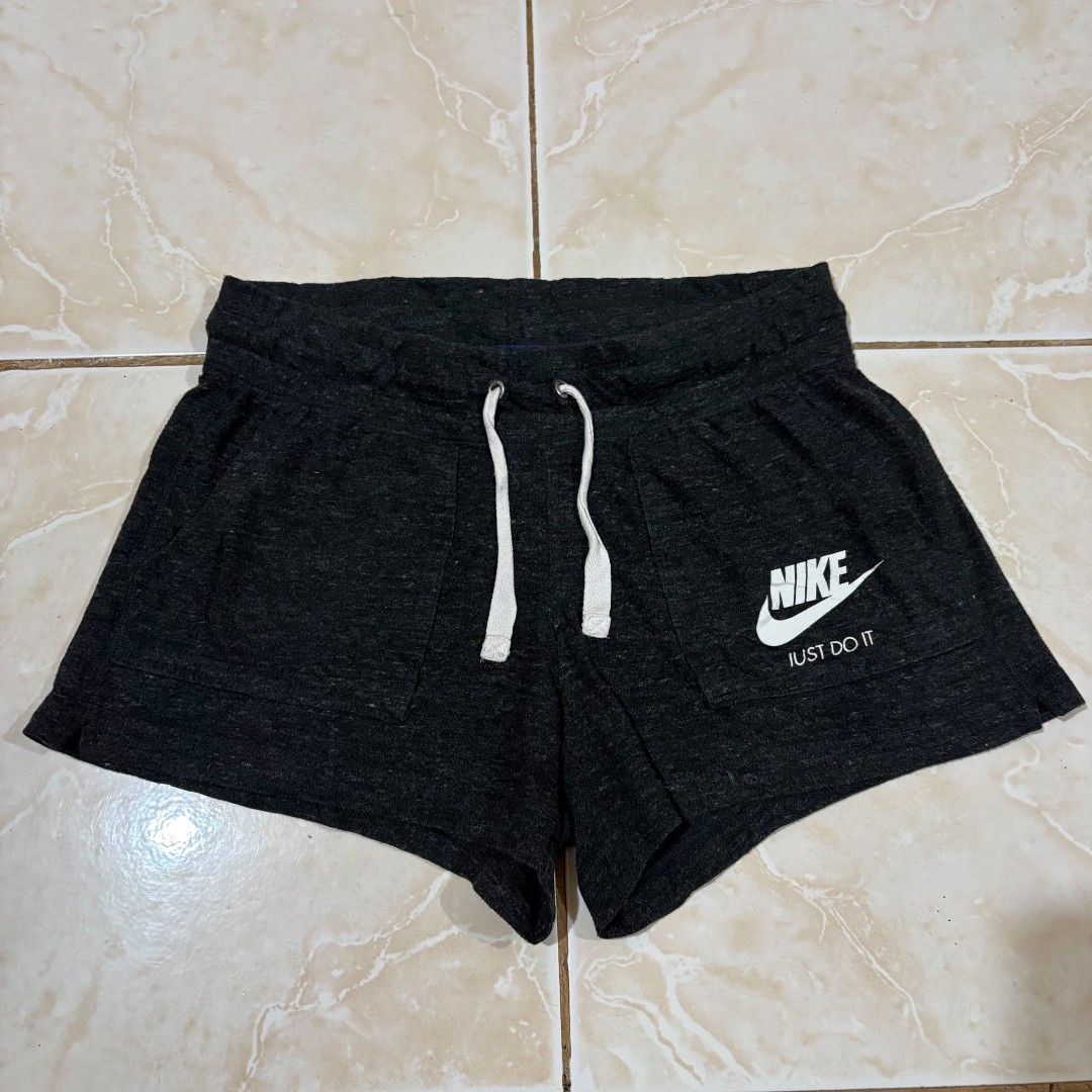 Nike Women's Charcoal Grey Drawstring Shorts (Category: Shorts) located in El Salvador. Submitted by pretiezt2001 (Listing ID 1470034121, Image 1). Description: - Brand: Nike - Color: Charcoal Grey - Material: Super soft fleece fabric - Design: Classic Swoosh logo and 'Just Do It' text on the front pocket - Features: Thick elastic waistband, white drawstrings with branded metal eyelets, and two front pockets - Condition: Great for lounging or cas