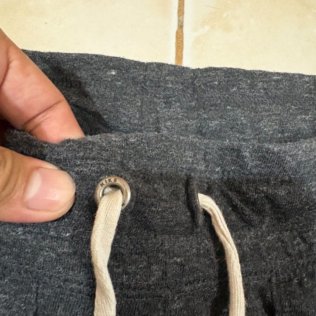 Nike Women's Charcoal Grey Drawstring Shorts (Category: Shorts) located in El Salvador. Submitted by pretiezt2001 (Listing ID 1470034121, Image 3). Description: - Brand: Nike - Color: Charcoal Grey - Material: Super soft fleece fabric - Design: Classic Swoosh logo and 'Just Do It' text on the front pocket - Features: Thick elastic waistband, white drawstrings with branded metal eyelets, and two front pockets - Condition: Great for lounging or cas