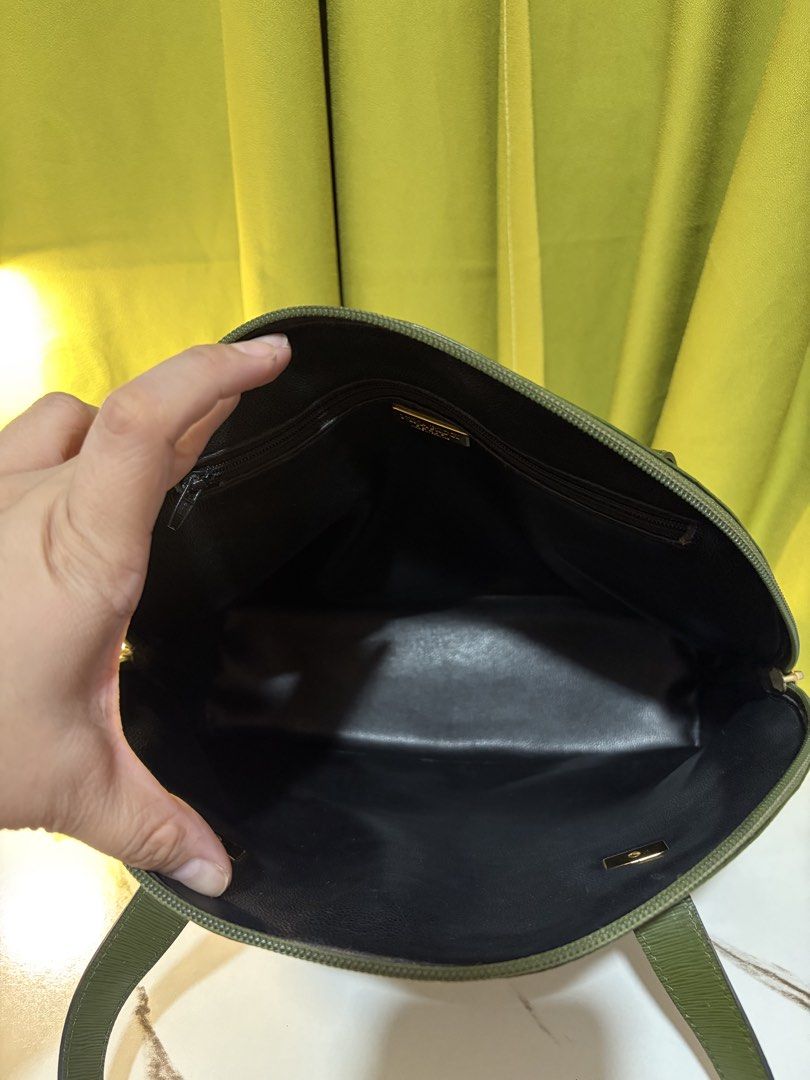 Nina Ricci Paris Shoulder Bag (Category: Shoulder Bags) located in Borongan. Submitted by charmspreloveddd (Listing ID 1470022802, Image 2). Description: - Brand: Nina Ricci Paris - Material: Premium green textured leather - Style: Dome-shaped tote with dual shoulder straps - Closure: Secure zip-top closure - Interior: Lined with a zippered pocket and gold-tone 'Made in France' logo plaque - Hardware: Distinctive metal 'NR' accents and matching f
