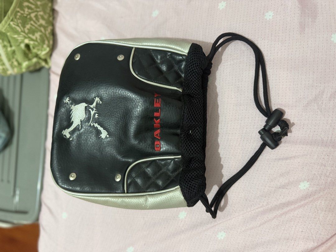 Oakley Black Quilted Drawstring Pouch Bag (Category: Purses & Pouches) located in Manila. Submitted by maambeeeeyah (Listing ID 1469980957, Image 2). Description: - Brand: Oakley - Color: Black and silver with striking red branding - Material: Quilted leather panels with breathable mesh side gussets - Features: Iconic silver oval logo on one side, red Oakley text on the other - Closure: Adjustable black drawstring cord - Interior: Fabric-lined wi