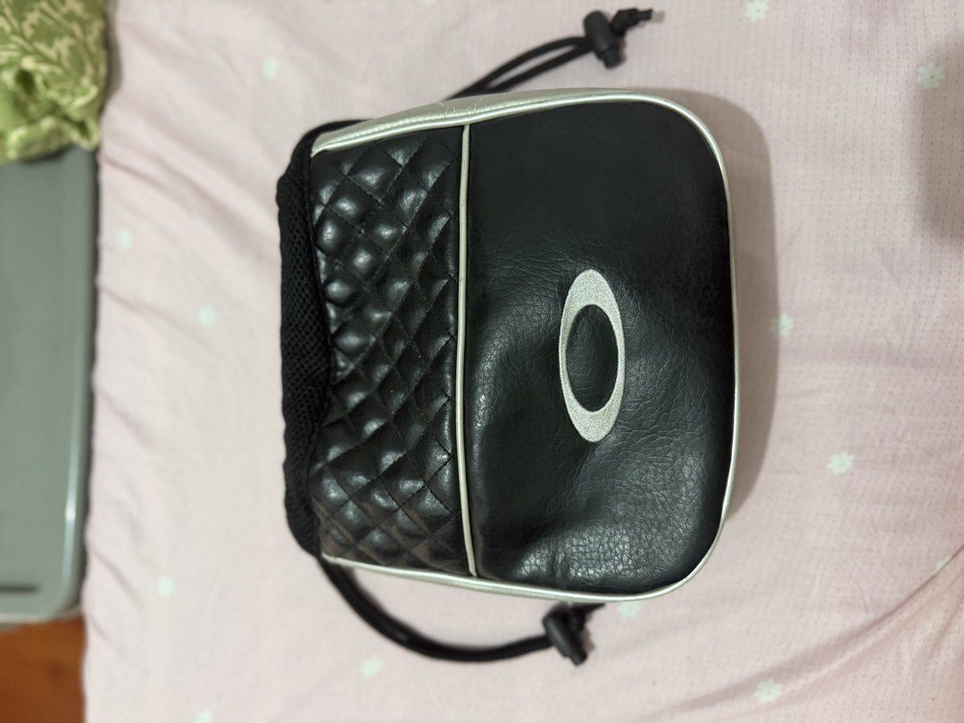 Oakley Black Quilted Drawstring Pouch Bag (Category: Purses & Pouches) located in Manila. Submitted by maambeeeeyah (Listing ID 1469980957, Image 1). Description: - Brand: Oakley - Color: Black and silver with striking red branding - Material: Quilted leather panels with breathable mesh side gussets - Features: Iconic silver oval logo on one side, red Oakley text on the other - Closure: Adjustable black drawstring cord - Interior: Fabric-lined wi
