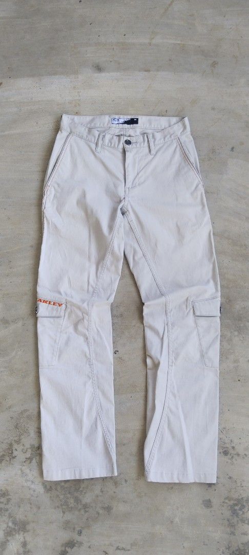 Oakley Cargo Pants Cream Size 30 (Category: Jeans) located in Manila. Submitted by 27moby (Listing ID 1470005912, Image 2). Description: - Brand/Model: Oakley Cargo Pants - Color: Cream - Size: Waist 30 - Material: Cotton-poly blend with stretch - Fit: Straight leg with front panel seam details - Pockets: Multiple utility pockets with button closures and back welt pockets with flap covers - Details: Distinctive orange Oakley embroidery on the rig