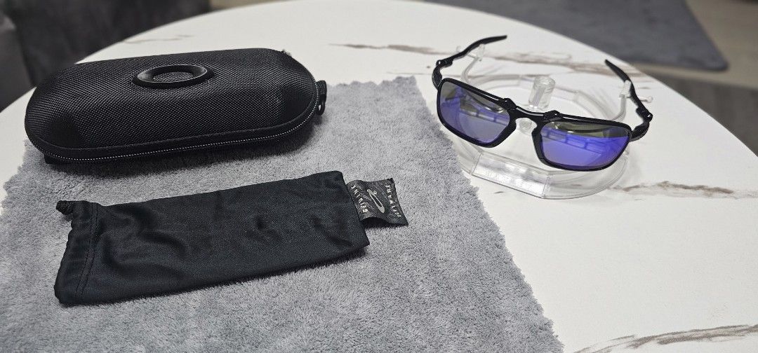Oakley Sunglasses with Case (Category: Sunglasses & Eyewear) located in Mabalacat. Submitted by hizoka122415 (Listing ID 1469960272, Image 3). Description: - Frame Color: Black - Lens Type: Purple mirrored, clean and well-kept - Ideal Use: Great for driving and outdoor activities on sunny days - Inclusions: Original hard case and soft microfiber pouch - Condition: Excellent, well-cared for 10/10 lens 10/10 frame 10/10 lens .