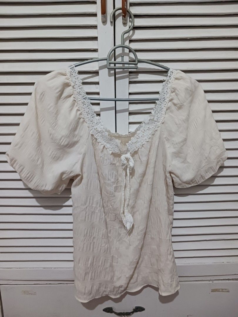 Off-shoulder cream blouse with lace trim (Category: Blouses) located in Quezon City. Submitted by rdonelle (Listing ID 1470081756, Image 1). Description: - Cream off-shoulder top with textured fabric - Short puff sleeves and front tie closure - Features delicate crochet lace trim - Ideal for warm weather or casual outings - Easy to pair with high-waisted jeans or skirts - Condition: Clean and ready to wear.