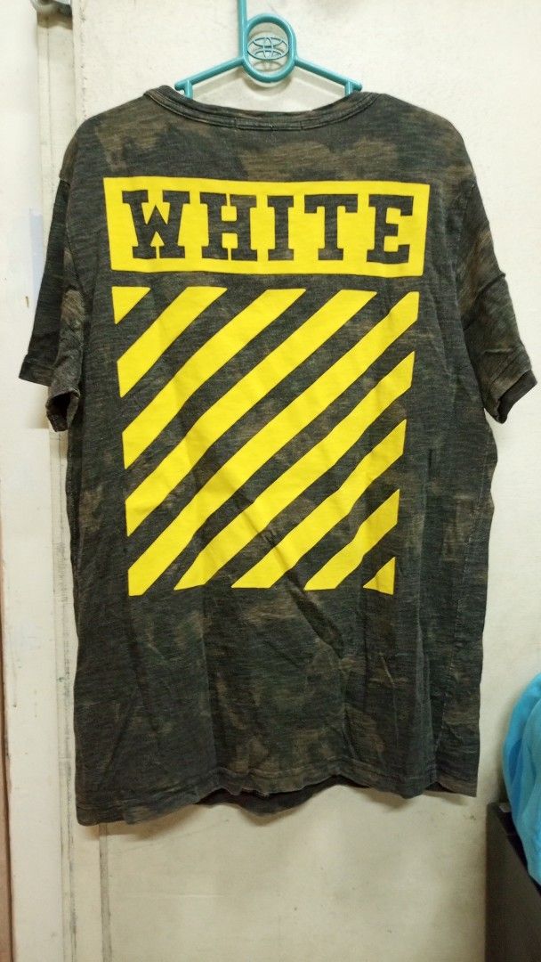 Off-White Camouflage Yellow Diagonal Print T-shirt (Category: Tshirts & Polo Shirts ) located in Manila. Submitted by rizu09 (Listing ID 1470040486, Image 1). Description: - Brand: Off-White - Item: Camo Tee - Size: Large (L) - Color/Wash: Dark grey and green camouflage - Details: Distressed collar and hems, big yellow box logo on upper back, diagonal stripes on lower back, small yellow text blocks near front hem - Material: Premium wool, polyest