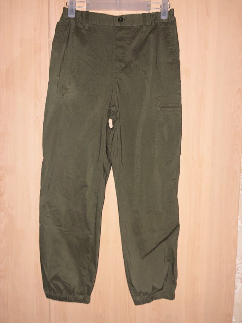 Olive green cargo pants with zipper pockets (Category: Jeans) located in Placer. Submitted by talaalond61563 (Listing ID 1469977883, Image 1). Description: - Color: Olive green - Style: Casual everyday fit utility cargo pants - Waistband: Elastic with button closure - Size: 150 - Pockets: Convenient zippered pocket on the side leg - Hem: Cured cuffs at the bottom ankles.