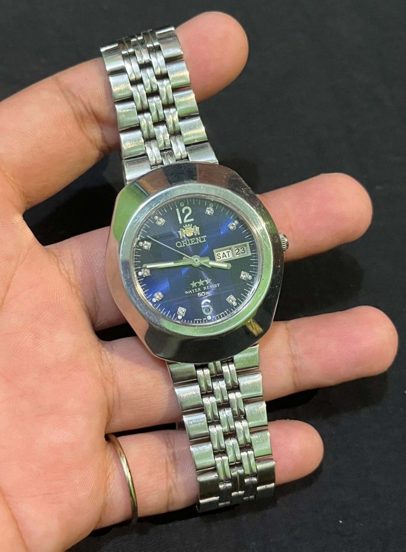 Orient 3 Star Blue Dial Automatic Watch (Category: Men's Watches) located in Cebu City. Submitted by jbok_watches. (Listing ID 1470101454, Image 3). Description: - Brand/Model: Vintage Orient 3 Star Automatic Watch - Dial: Striking blue patterned dial with crystal hour markers and 12/6 digits - Case & Strap: Silver stainless steel case and matching bracelet with signed logo clasp - Features: Day and date window at the 3 o'clock position - Movemen