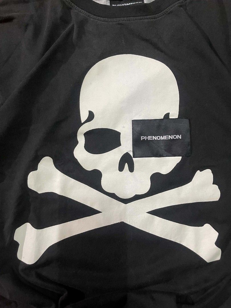 Phenomenon x Mastermind Japan Skull T-Shirt (Category: Tshirts & Polo Shirts ) located in Ozamiz City. Submitted by tripft.vonde (Listing ID 1470048503, Image 2). Description: - Brand: Phenomenon x Mastermind Japan Collaboration - Size: L - Design: Large front skull and crossbones graphic with branded tag overlay - Back Details: Phenomenon and Mastermind Japan text with smaller skulls - Unique Feature: Contrasting grey right sleeve and matching r