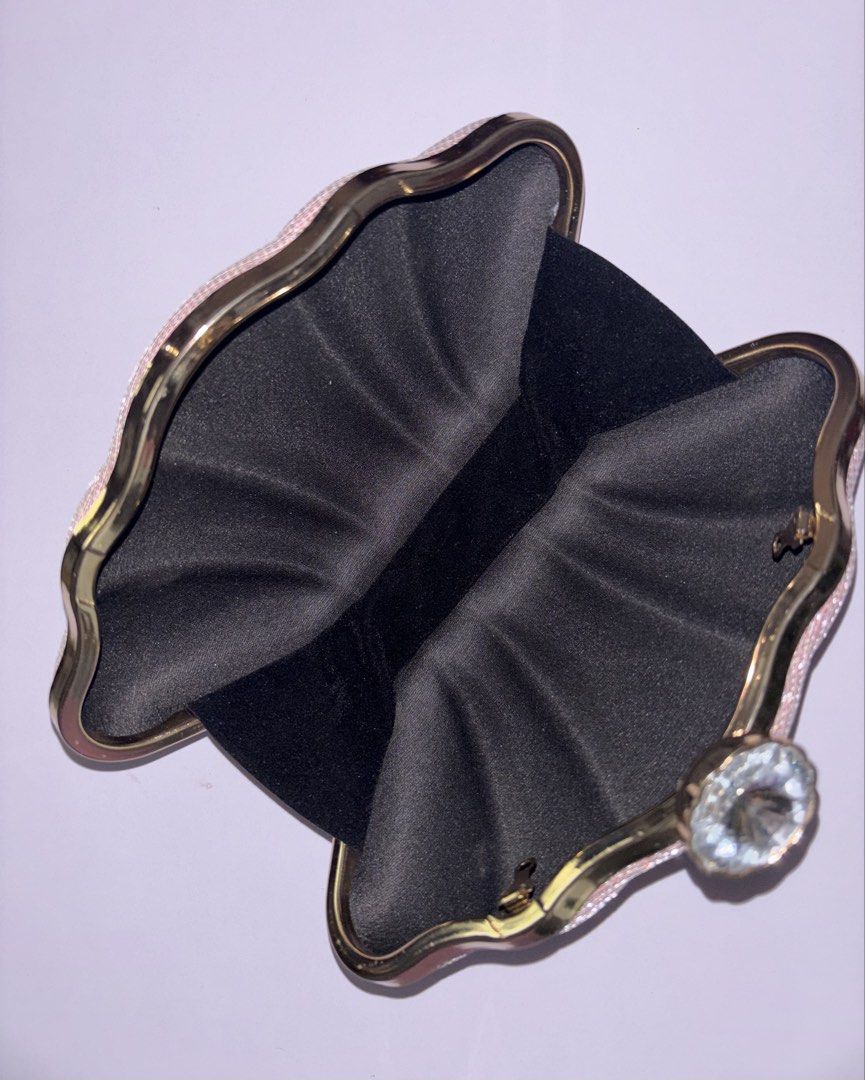 Pink glitter evening clutch with crystal clasp (Category: Clutches) located in Manila. Submitted by chn.ph (Listing ID 1469994651, Image 2). Description: 🐚 Color & Finish: Sparkly pink hard shell with all-over pleated texture 🧜‍♀️ Interior: Black fabric lining with enough space for your cards and lipstick 🪸Occasion: Ideal evening bag for weddings, parties, or dinner dates (Note: Used only once, but the metal chain strap is missing.).