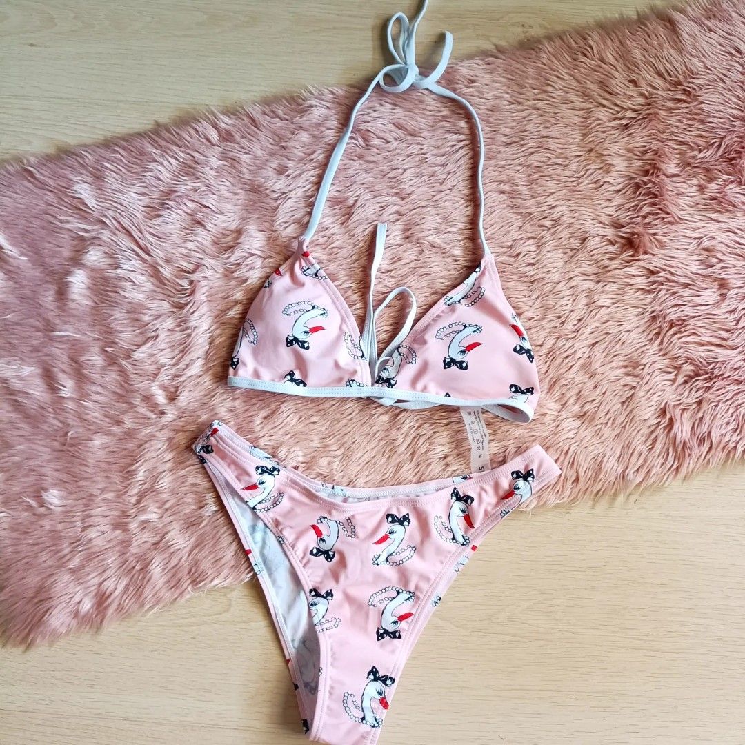 Pink Swan Print Halter Bikini Set (Category: Bikinis & Swimsuits) located in Bacoor. Submitted by Miss_Chuch0521 (Listing ID 1470053097, Image 1). Description: - Pink two-piece bikini with adorable swan and pearl necklace pattern - Triangle halter top with adjustable neck and back ties for a custom fit - Matching low-rise cheeky bottoms with chic white trim details - Ideal for pool parties, beach days, and summer getaways - DM for measurements or