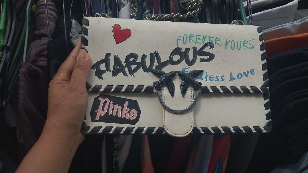 Pinko LOVE Fabulous (model 1P21DD) (Category: Luxury Bags & Wallets) located in Manila. Submitted by jonahq.9 (Listing ID 1470138690, Image 1). Description: Pinko LOVE Fabulous Graffiti Crossbody Bag (Model 1P21DD)! ✨ Iconic Pinko Love Bag – famous swallow‑bird lock, graffiti "Fabulous / Forever Yours" print, black braided trim, silver chain! Preloved AS‑IS: may peeling sa edge, yellowing at signs of use (see pics); zipper looks okay; DM para sa 