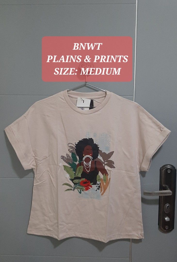 Plains & Prints Graphic T-Shirt (Category: Tshirts & Polo Shirts ) located in Manila. Submitted by gleeshoppe_lee (Listing ID 1470080547, Image 2). Description: - Brand: Plains & Prints - Condition: Brand new with tags (BNWT) - Color: Beige - Size: Medium - Design: Woman and botanical print on the front - Details: Crew neckline, short sleeves with rolled cuffs.