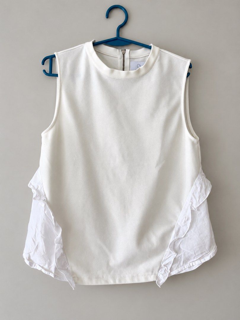 Plains & Prints White Sleeveless Top with Ruffles (Category: Sleeveless) located in Cabanatuan. Submitted by yass03_loved (Listing ID 1469976585, Image 1). Description: - Brand: Plains & Prints - Color: White - Style: Sleeveless top with round neckline and exposed gold back zipper - Detail: Contrasting white ruffled panels along both sides - Condition: Clean, crisp, and well-maintained - Fit/Styling: Minimalist design, easy to pair with high-wais